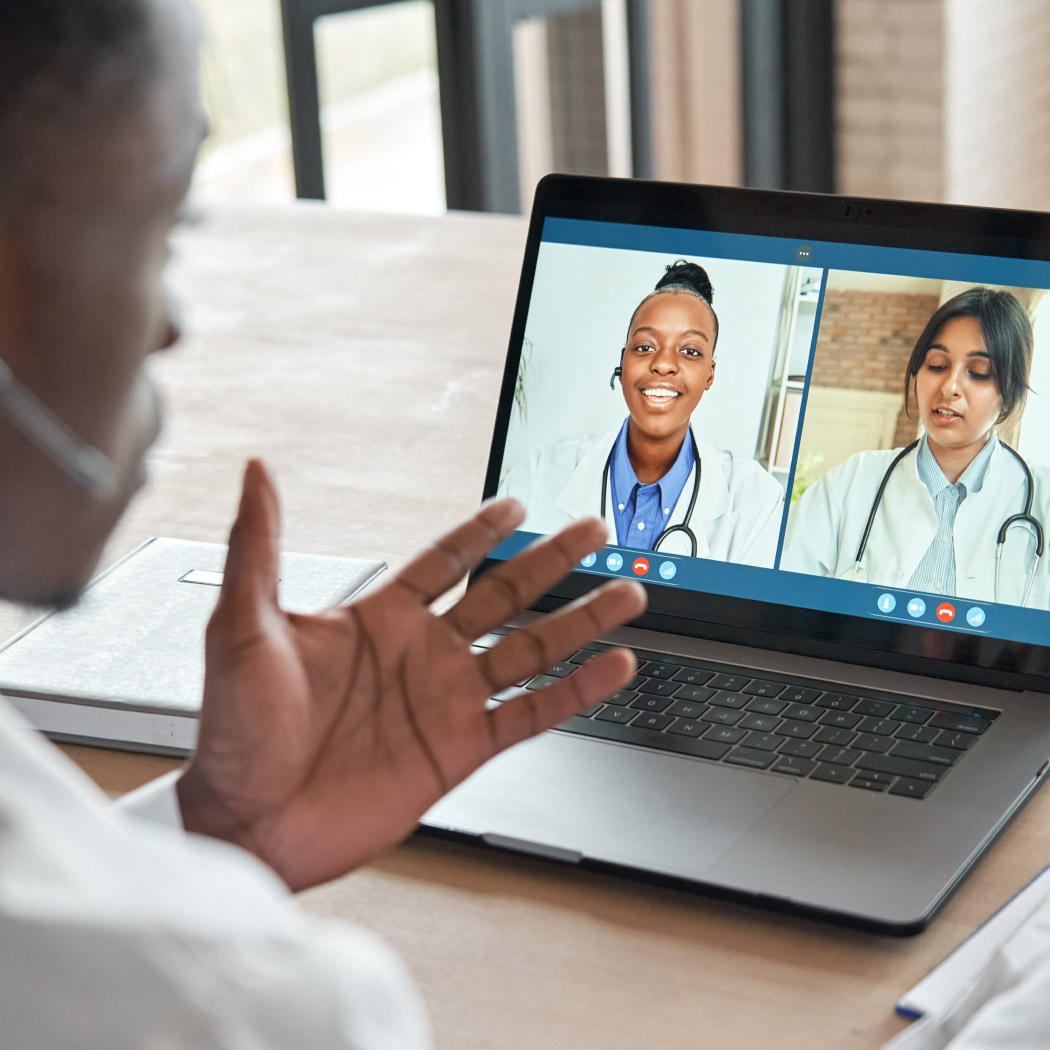 A CareScout professional video conferences with two healthcare professionals